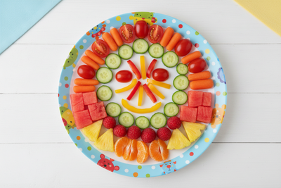 A children's plate filled with colourful vegeables