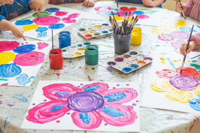 preschool kids painting a colourful picture of flowers